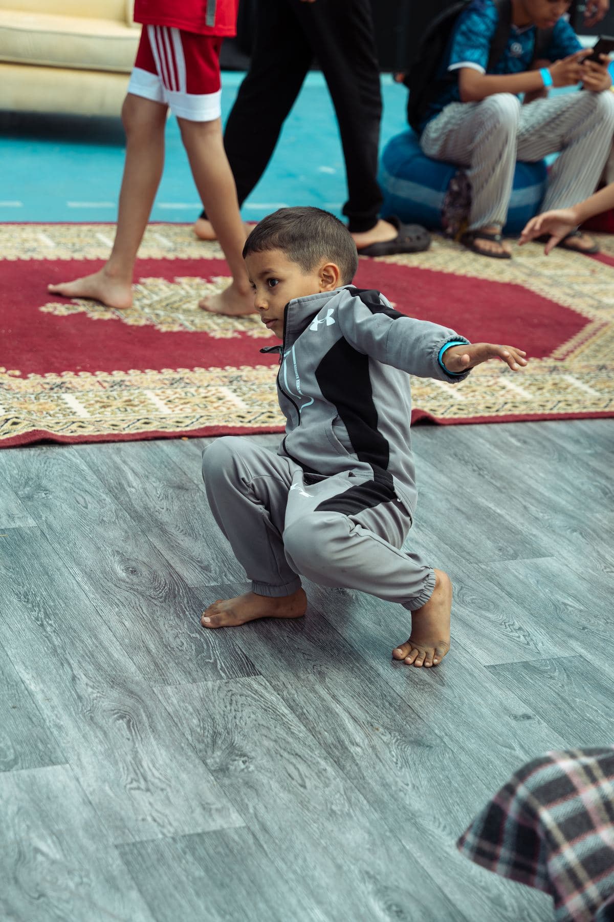 Un tout-petit en équilibre sur un tapis, pendant une initiation.