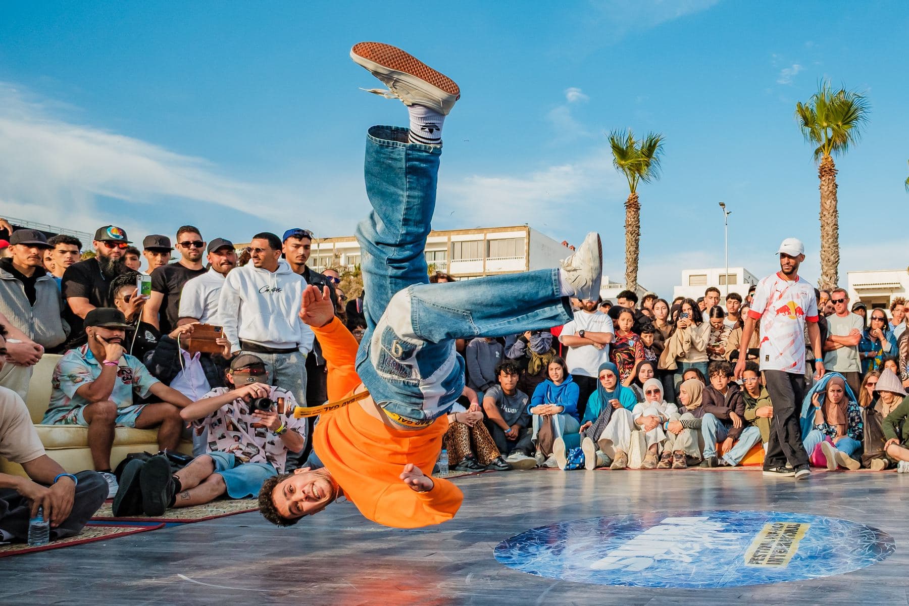 Un danseur en freeze sur la tête, au centre du cercle.