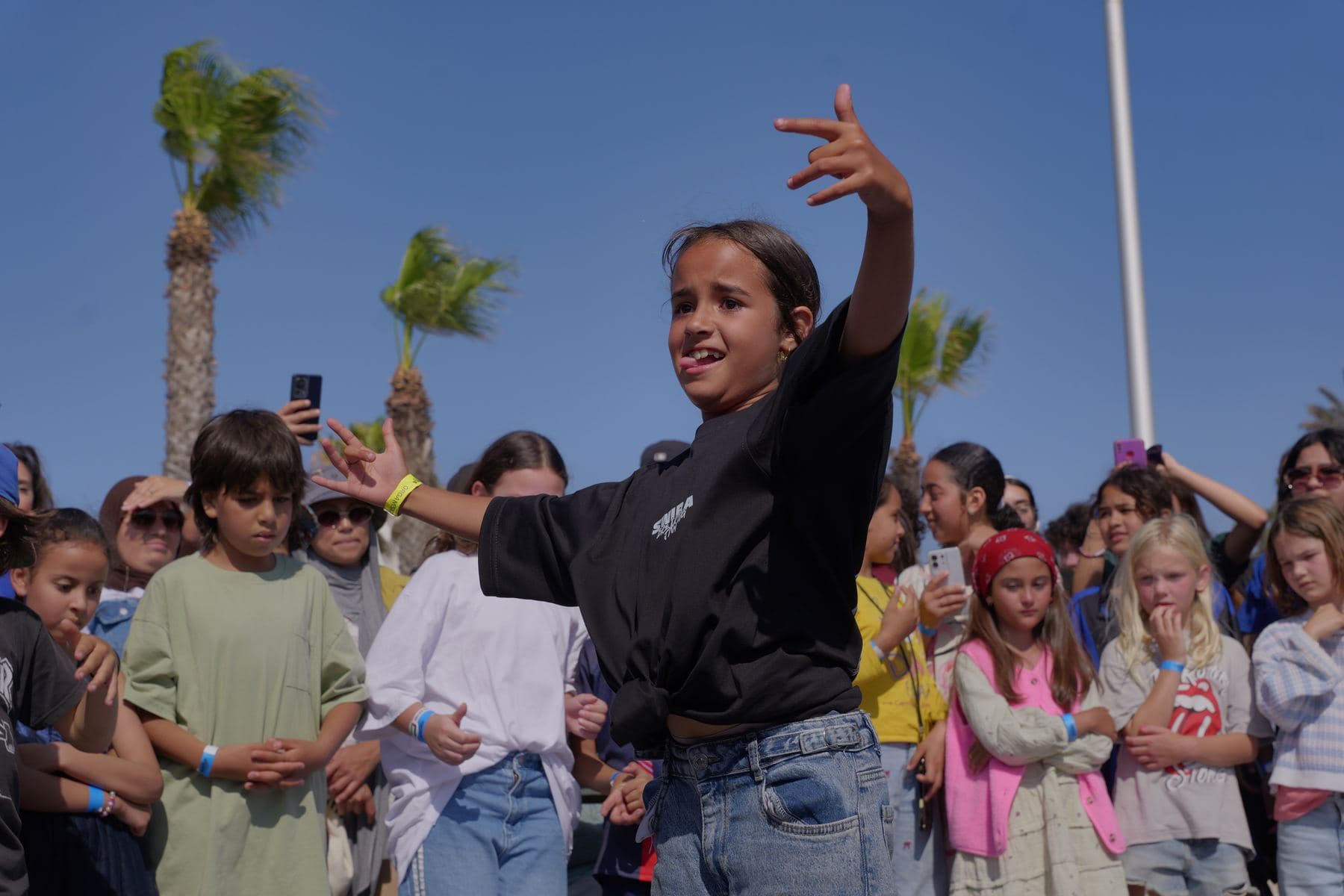 Une jeune danseuse au centre du cercle, entourée d'enfants, pendant la Swira Breaking Jam 2026.