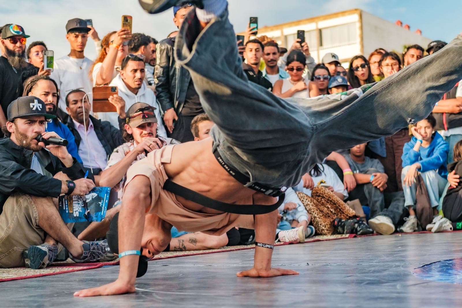 Un danseur au sol, en appui sur une main, les jambes lancées.